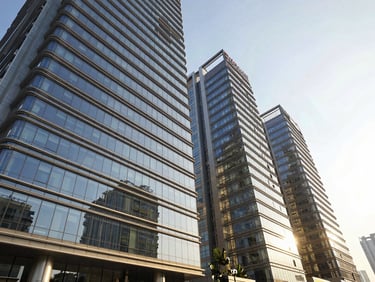 Modern glass high-rise exterior of DLF The Magnolias, bright natural sunlight, wide-angle lens