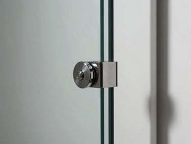 Extreme close-up of a frameless glass wine room door corner joint, polished hardware clip at the corner, clean glass edge, cool studio light, white wall surround, no people