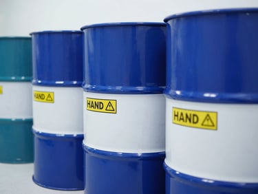 Close-up of clean, sealed industrial chemical drums with professional hazard labels, clinical laboratory white light, high-contrast