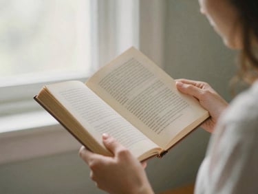 Authentic woman reading an old, open book in soft morning light, hands gently holding the pages, shallow depth of field, 35mm film grain
