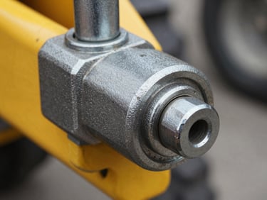Detailed close-up of a greasable pivot pin assembly on a tractor loader joint, metallic textures, 35mm.