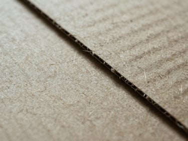 Extreme macro shot of clean, dry cardboard fiber composition, showing high-density kraft paper texture under cool-toned industrial lighting, sharp details.