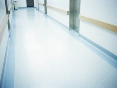 High-key sterile hospital corridor with clean light-colored floors, bright daylight, clinical environment, 35mm