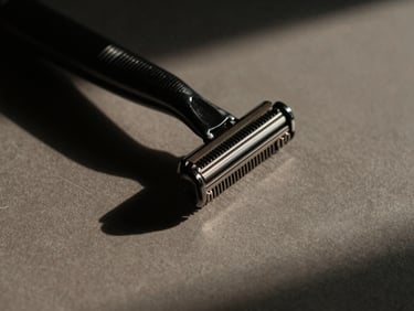 Close-up of a high-end grooming tool (e.g., razor or comb) casting a sharp shadow, abstract and desaturated, emphasizing precision and control.