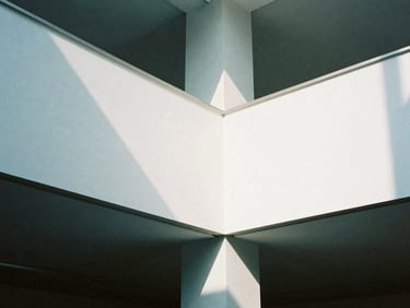 Close-up of a modern corporate interior, clean lines, stark white walls, cool daylight, sharp shadows, 35mm film