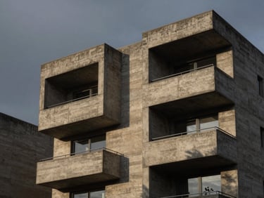 Architectural detail of a brutalist concrete estate, sharp geometric lines against a dark moody twilight sky, dramatic shadow play.