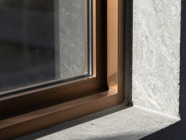 Extreme close-up of modern architectural concrete and bronze window frames, sharp shadows
