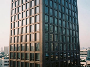Clean, modern interior of a high-rise building in a major Asian financial district, soft natural daylight, subtle reflections, 35mm film.