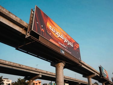 Low-angle heroic perspective of a massive highway gantry billboard in Delhi-NCR during high-contrast urban daylight.