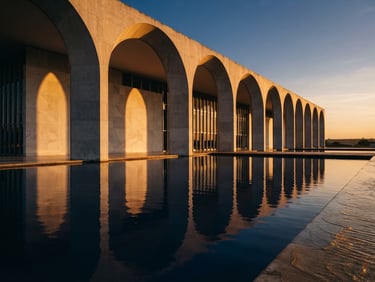 Wide-angle architectural photograph of the Itamaraty Palace arches in Brasília, dramatic golden hour shadows, deep navy reflections on polished concrete, wide-angle lens, clean minimalist composition
