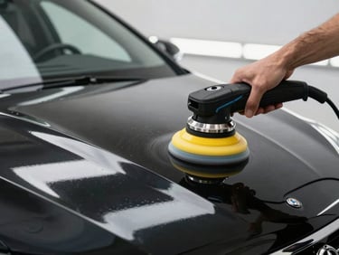 Aesthetic preparation of a car exterior, professional dual-action polisher reflecting bright LED workshop lights on a flawless black hood