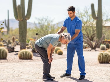 Professional physical therapist demonstrating a safe bending technique to a senior client in a sunlit desert garden, saguaro cacti in background, natural Arizona sunlight, medium shot.