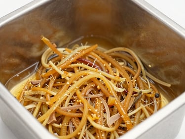 Close-up of raw organic ingredients being mixed in a stainless steel container, warm amber tones, clean clinical lighting