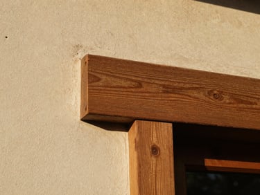 Close-up of textured rough plaster and aged oak joinery, soft golden hour light, architectural detail, 35mm film grain