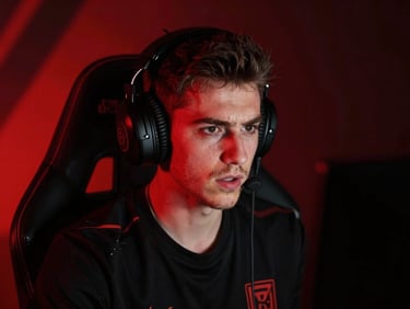 Close-up of a competitive streamer in a dark setup with heavy red backlighting, intense expression, monitor-glow key light, 35mm lens