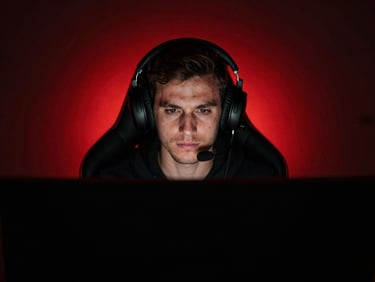High-contrast portrait of a gamer wearing a headset in a low-key dark room, monitor-glow lighting, red backlight, 35mm lens