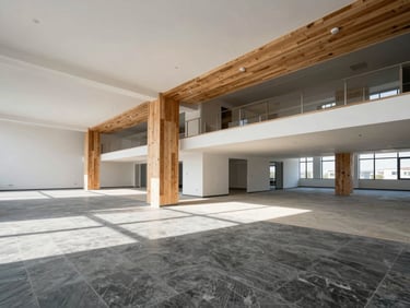 Wide-angle shot of a newly finished commercial office space, showing open-plan layout, structural elements, and clean design, bright natural daylight.