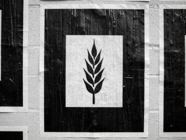 Close-up shot of black and white wheatpasted posters on a brick wall with direct flash lighting, wet paper texture.