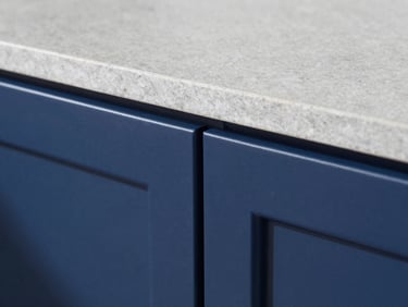 Macro close-up of a perfectly refinished kitchen cabinet edge, flawless satin navy blue finish, sharp architectural detail, bright clean daylight