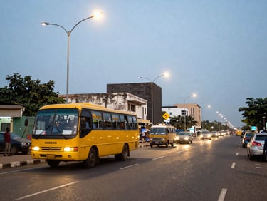 Wide environmental shot of the bustling Lagos commercial district at dusk, streetlights starting to glow, a yellow Danfo bus in motion on the left third, realistic 35mm documentary style.