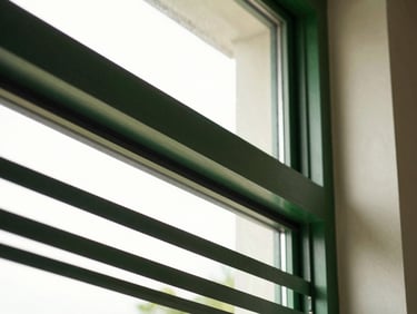 Architectural detail of custom pleated protective grills integrated into a modern window frame, high-contrast light, 35mm
