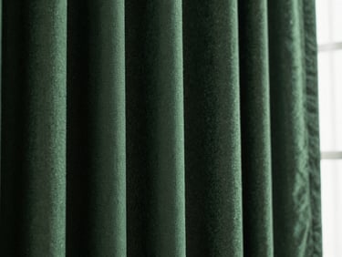 Macro close-up of heavy hunter green curtain fabric texture with deep folds and dramatic side lighting, 35mm