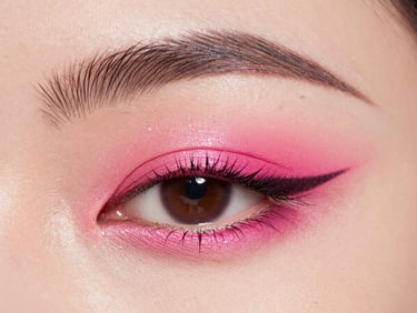 Extreme macro shot of a graphic eyeliner look on a model, vibrant hot-pink eyeshadow, sharp studio strobe lighting