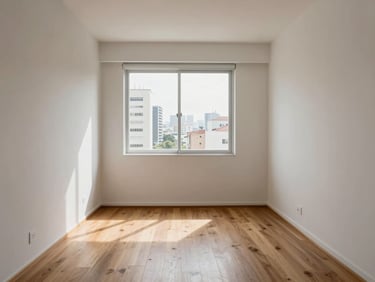 Interior of a compact studio apartment in São Paulo, natural morning light through a large window, light wood flooring, white walls, minimal furniture showing functional scale and clean finishes