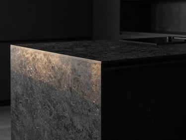 Minimalist kitchen island made of dark charcoal quartz, sharp focus on the seamless joints and polished edge profile, dramatic side-lighting