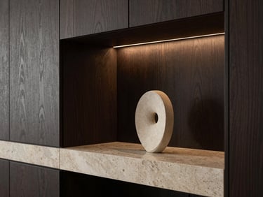 Close-up of a high-end apartment interior, custom dark oak wall panels, integrated warm lighting, minimalist sculpture on a travertine plinth.