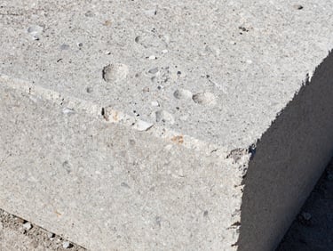 Close-up of raw textured limestone block being laid with millimeter precision, harsh natural side light highlighting the grain, gritty documentary photography, high contrast, 35mm