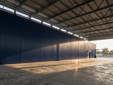 Interior of a modern Grade-A logistics warehouse in Dehradun, expansive clean concrete floors, high ceilings with steel trusses, bright morning light