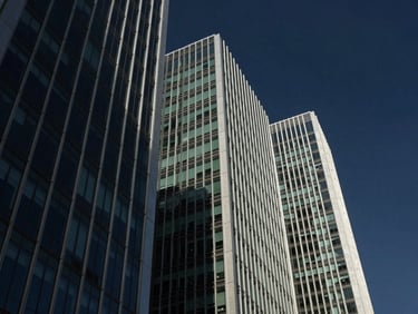 Modern architectural details of a financial district skyscraper looking up, steel and glass facades, deep navy sky, sharp shadows, 35mm