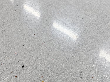 Macro shot of a seamless vinyl flake floor texture, showing various colored flakes embedded in a clear topcoat, high-contrast lighting, sharp focus.