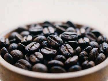 Close-up of roasted coffee beans in a rustic wooden bowl, soft overcast daylight, warm tones, 35mm lens