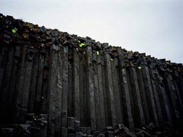 Moody overcast basalt column cliffs in Iceland, dark desaturated tones, 35mm