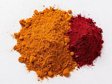 Overhead shot of vibrant orange turmeric and deep red beetroot powders in neat geometric mounds, high-contrast minimalist background