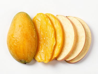 Overhead studio shot of dehydrated mango and apple slices arranged neatly, vibrant organic colors, high-key daylight