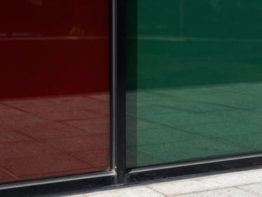Minimalist architectural detail of triple-glazed glass pane meeting a matte black steel frame, crisp daylight