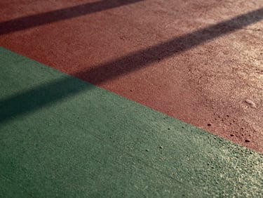 Orthographic macro shot of textured poured concrete surface, sharp low-angle golden hour light, deep shadows