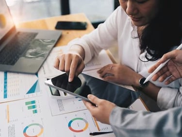 a man and woman sitting at a desk with a tablet