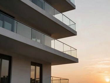 Cantilevered balcony of a luxury apartment in Bhayli at golden hour, minimalist glass railings, sunset sky.
