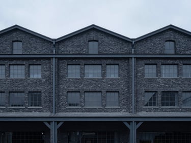 Minimalist architectural photography of a rehabilitated industrial brick warehouse with modern steel frames, cool overcast day