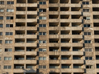 Close architectural crop of a Brasília apartment facade with concrete cobogós, soft afternoon light filtering through the geometric patterns.