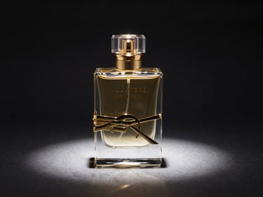 Premium glass perfume bottle of ALLUMERE AMITREA on a dark reflective surface, gold accents shining under dramatic spotlight, high-contrast studio photography