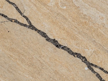 Macro material detail of premium quartz slab veining, crisp studio lighting, warm stone and charcoal tones, sharp focus, 35mm
