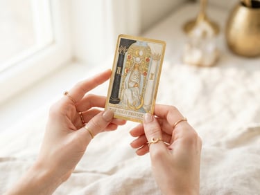 Luminous editorial photography, close-up of delicate hands with gold rings holding a single gold-rimmed tarot card, bright natural daylight, soft golden highlights, 35mm