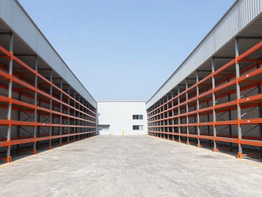 Symmetrical architectural shot of a clean industrial warehouse with safety orange racking, bright daylight, high contrast cool tones