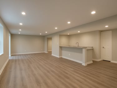 Wide interior shot of a finished basement in a Delaware home — recessed lighting, painted drywall, LVP flooring, a small bar area to one side, daylight-balanced artificial light, no people