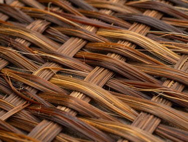 Close-up of smoked water hyacinth weave, fibres deep amber-brown, photographed under diffuse daylight, rich tonal variation in the weave visible, no props